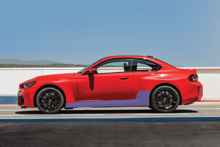 Rocker panel protection kit installed on a red BMW M2 for enhanced durability and style.
